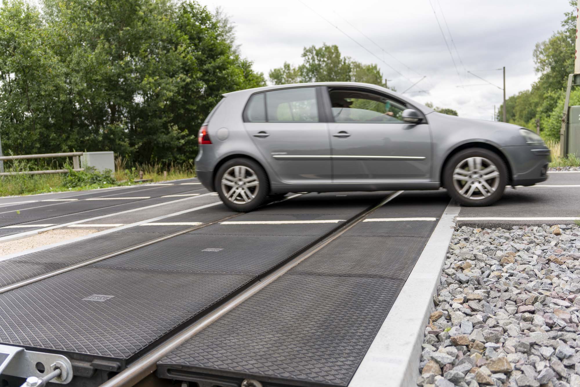 B Bordstein im Bahnübergang mit Auto
